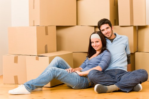 Professional movers carrying furniture on a residential Croftonpark street